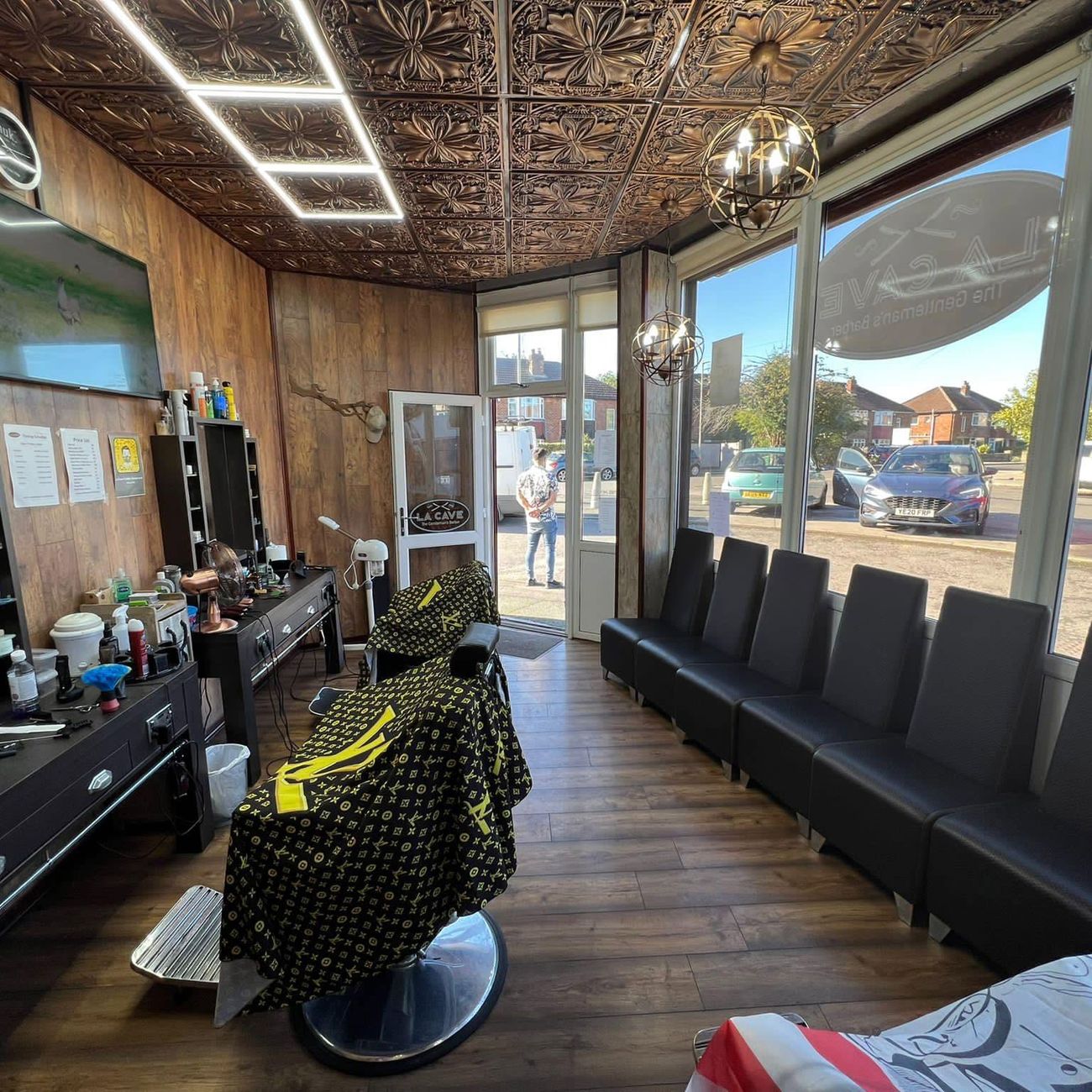 Two barber chairs in La Cave with a row of leather waiting seats