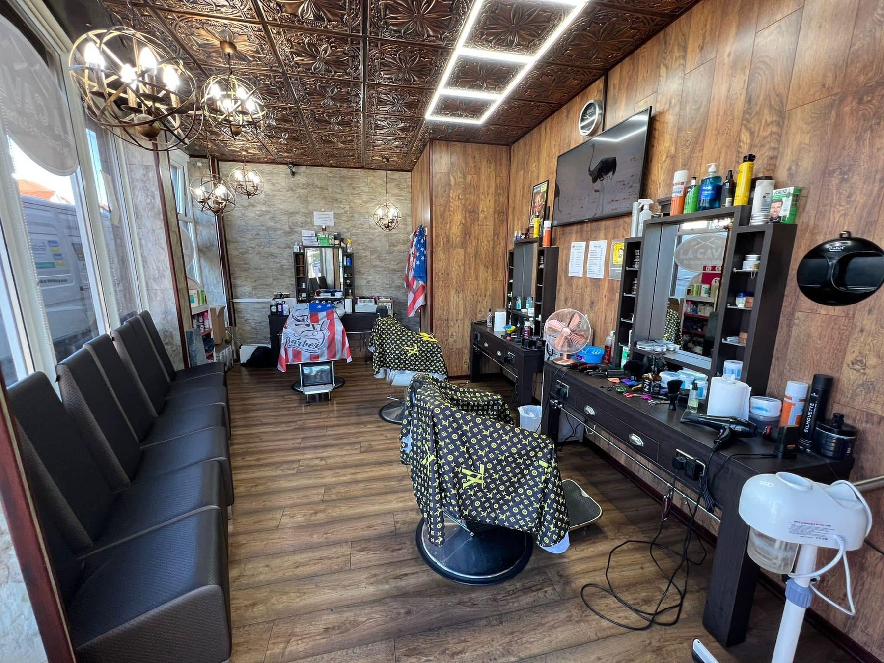 Inside La Cave: pressed-tin ceiling, chandeliers, wood panelling and leather barber chairs