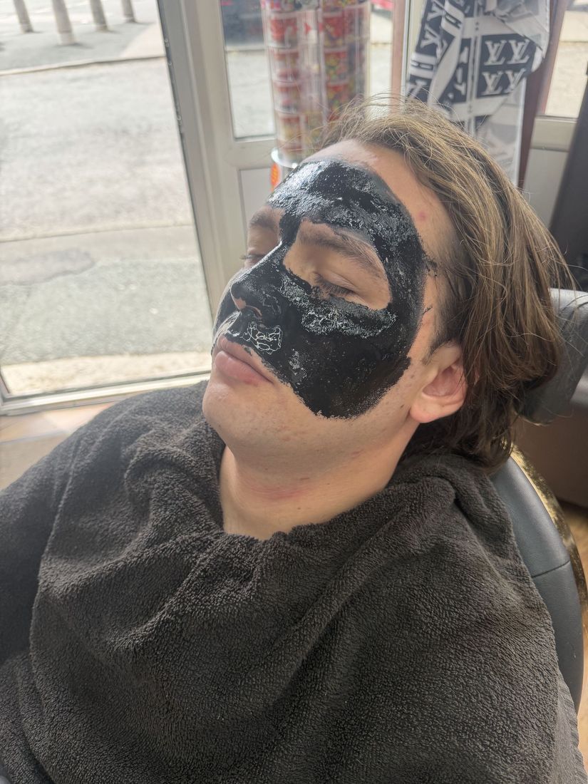 A customer resting in the chair with a black face mask on