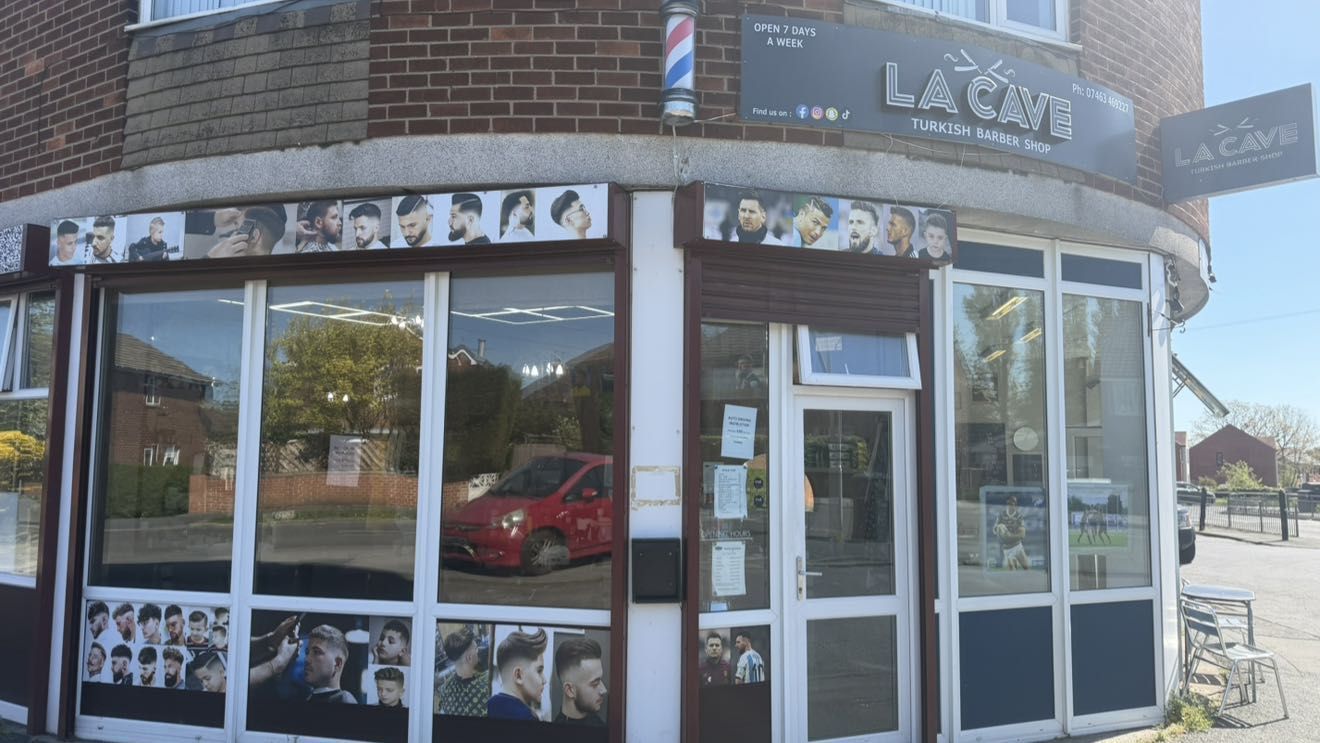 La Cave shop window with the hairstyle posters